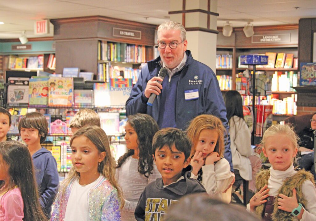 David Feldman, head of Emerson School, speaks into a microphone at an event at Schuler Books.