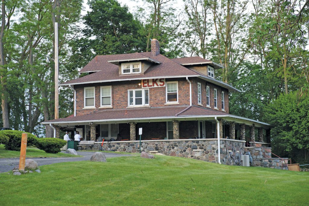 The exterior of the Black Elks Lodge, a brown building with a stone porch.