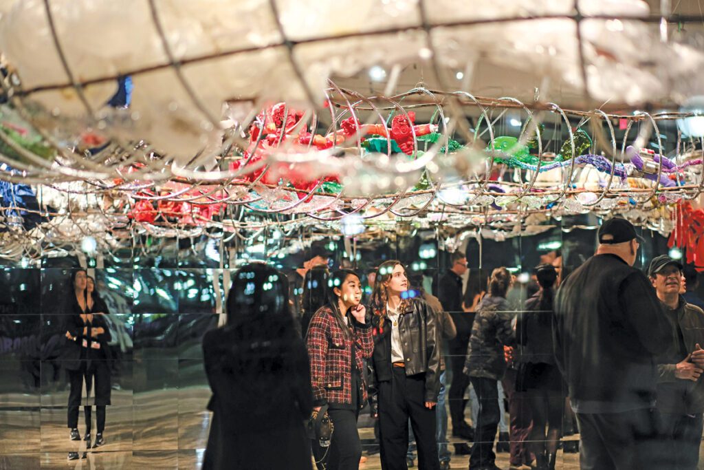 An audience stand underneath Ouroboros, a snakelike sculpture made out of garbage. 