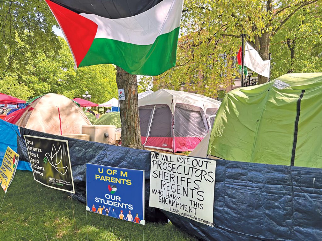 Palestinian flags hanging above an encampment on the U-M Diag.