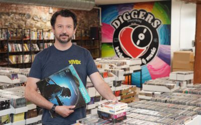 Man in a media store holding records.