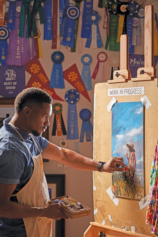 A man painting on an easel.