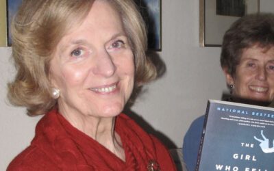 A smiling woman holding a book.