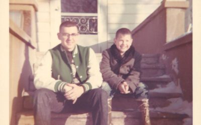 Old photo of two boys sitting on stairs.