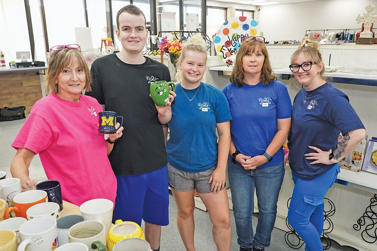 Five people standing in a store.