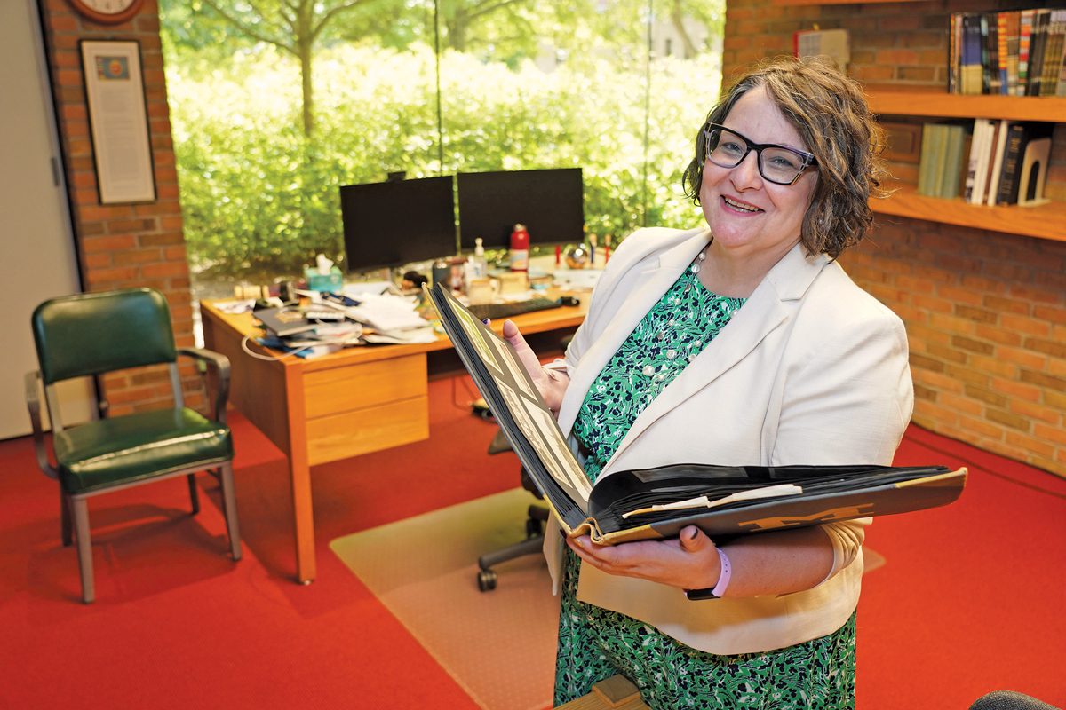 Alexis Antracoli holding a book in her office