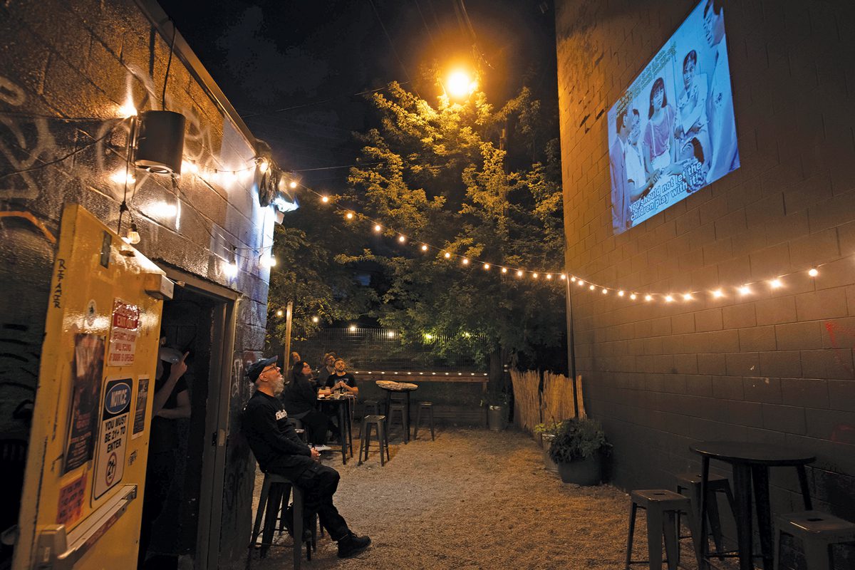 People watching movies on a patio at night.