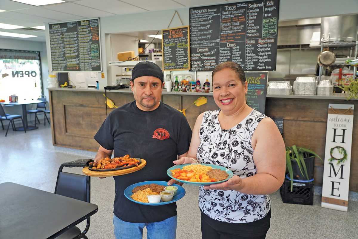 Two people holding Mexican food.