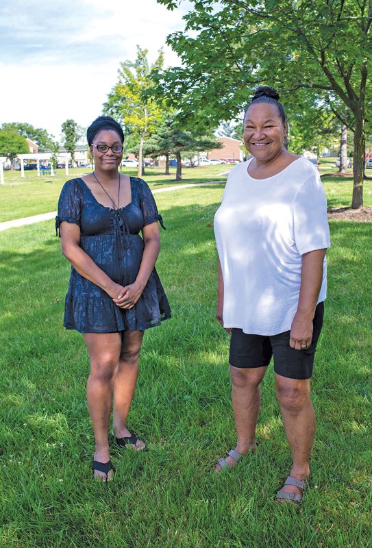 Two women standing on a lawn.