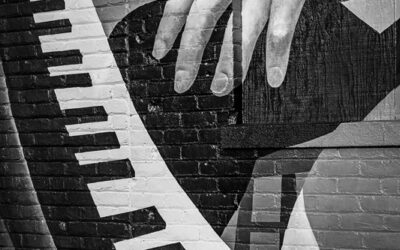 A close-up photo of a mural of hands playing a piano.