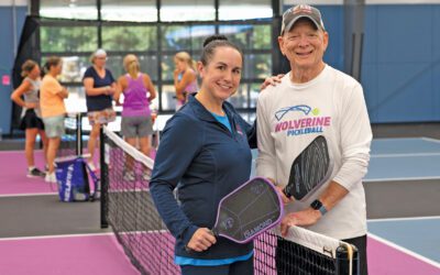 Ken Monash and Kabrina Rozine holding pickleball paddles on a pickleball court