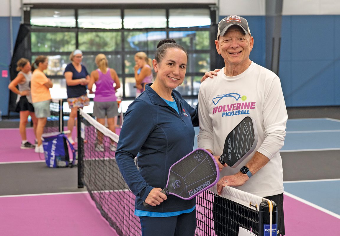 Ken Monash and Kabrina Rozine holding pickleball paddles on a pickleball court