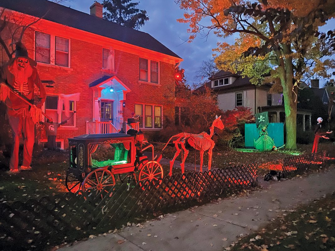 Halloween decorations in front of a red-lit house