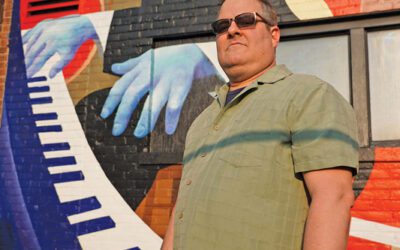 Rick Roe standing in front of a mural of Thelonious Monk