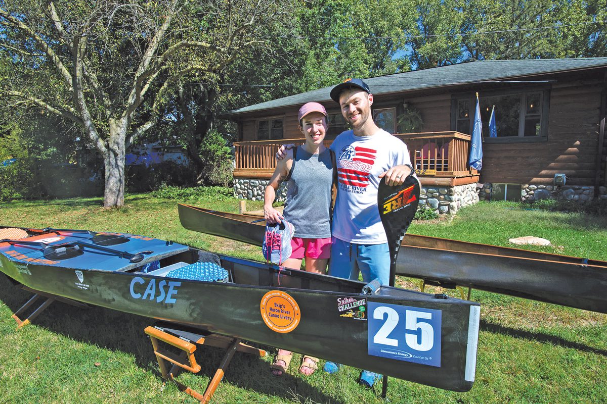 Hayley Billingsley and Case Kittel standing next to a canoe in their yard.