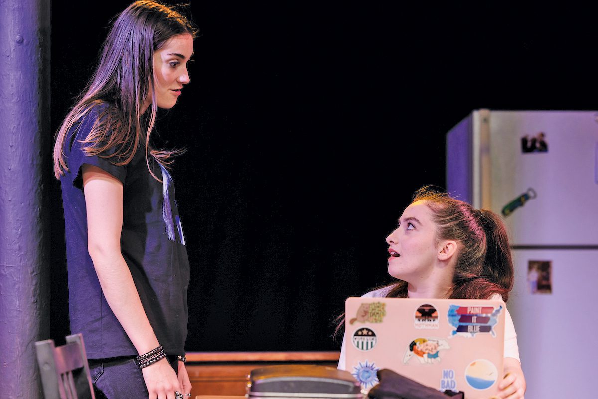 Two young women standing onstage.