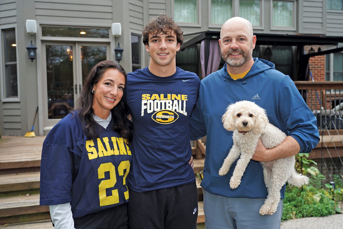 Janine, Coleman, and Brad Ross. Brad is holding a small white dog.