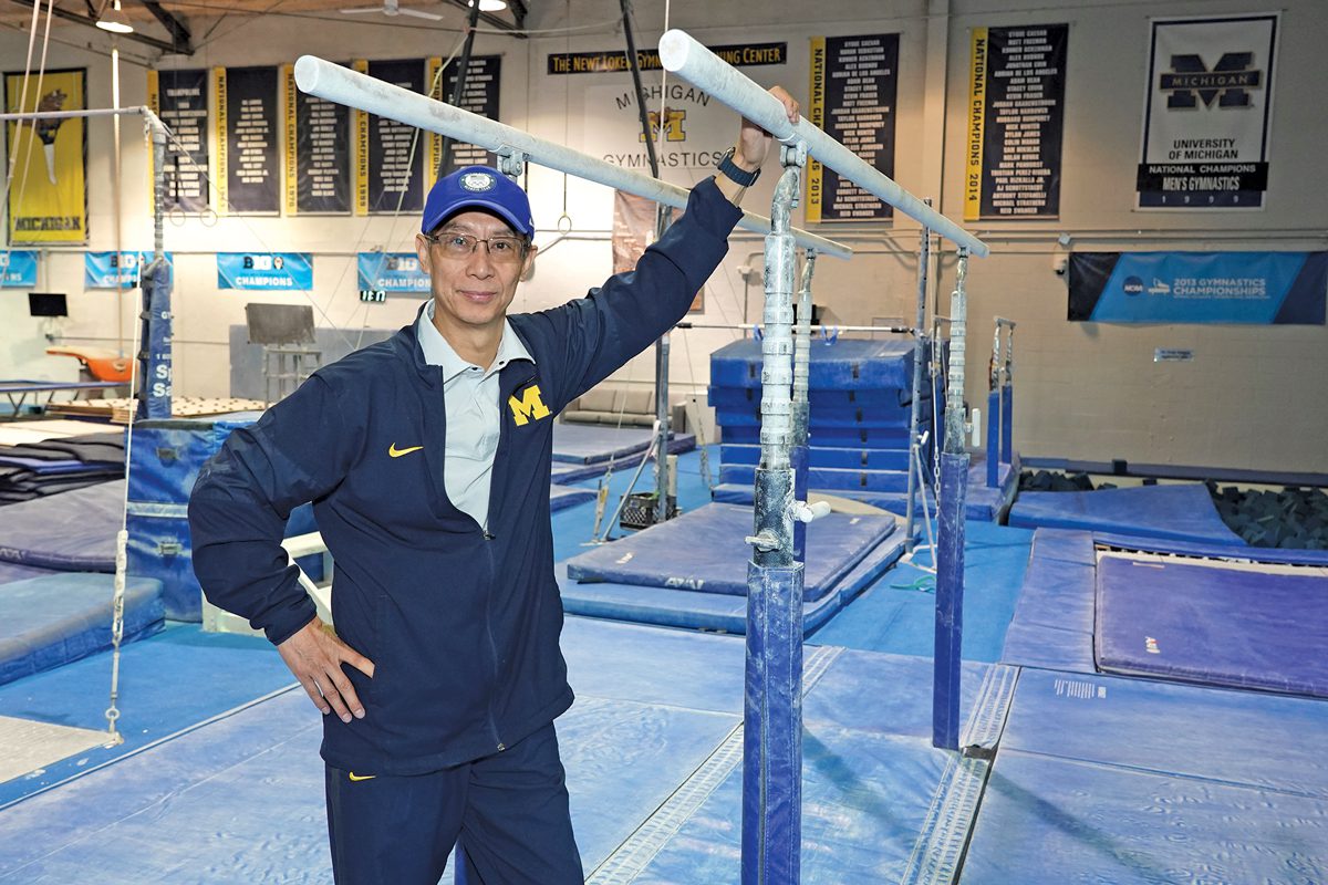 Yuan Xiao in a blue uniform standing in a gymnastics practice area.