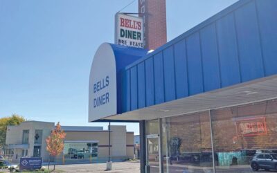 An awning and sign for a diner partially obscuring a brick chimney. On the chimney, the letters WO are visible.