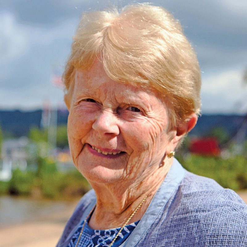 Ann Taber standing outside, wearing a blue top and smiling