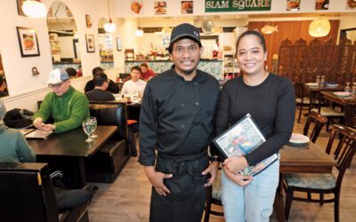 Brother and sister standing in their restaurant.