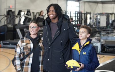 Bryce Underwood standing between a woman and a kid