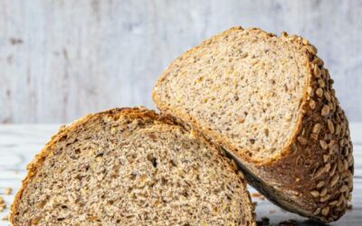 a loaf of 8-grain 3-seed bread cut in half with the top half leaning on the bottom half