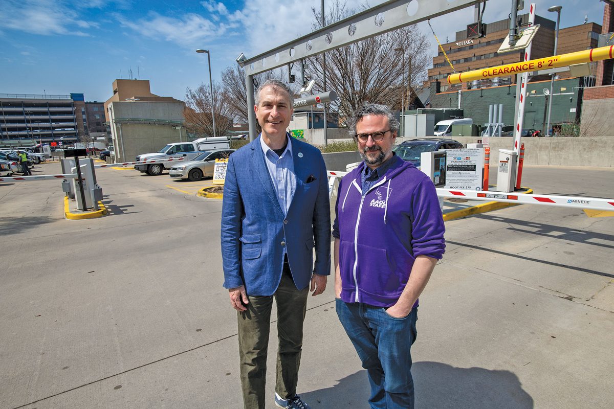 Two men standing in a parking lot.