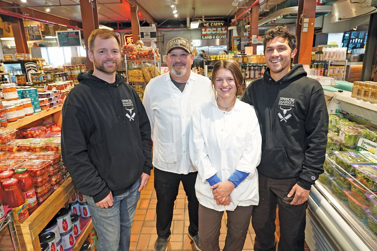 Four people standing in a shop.