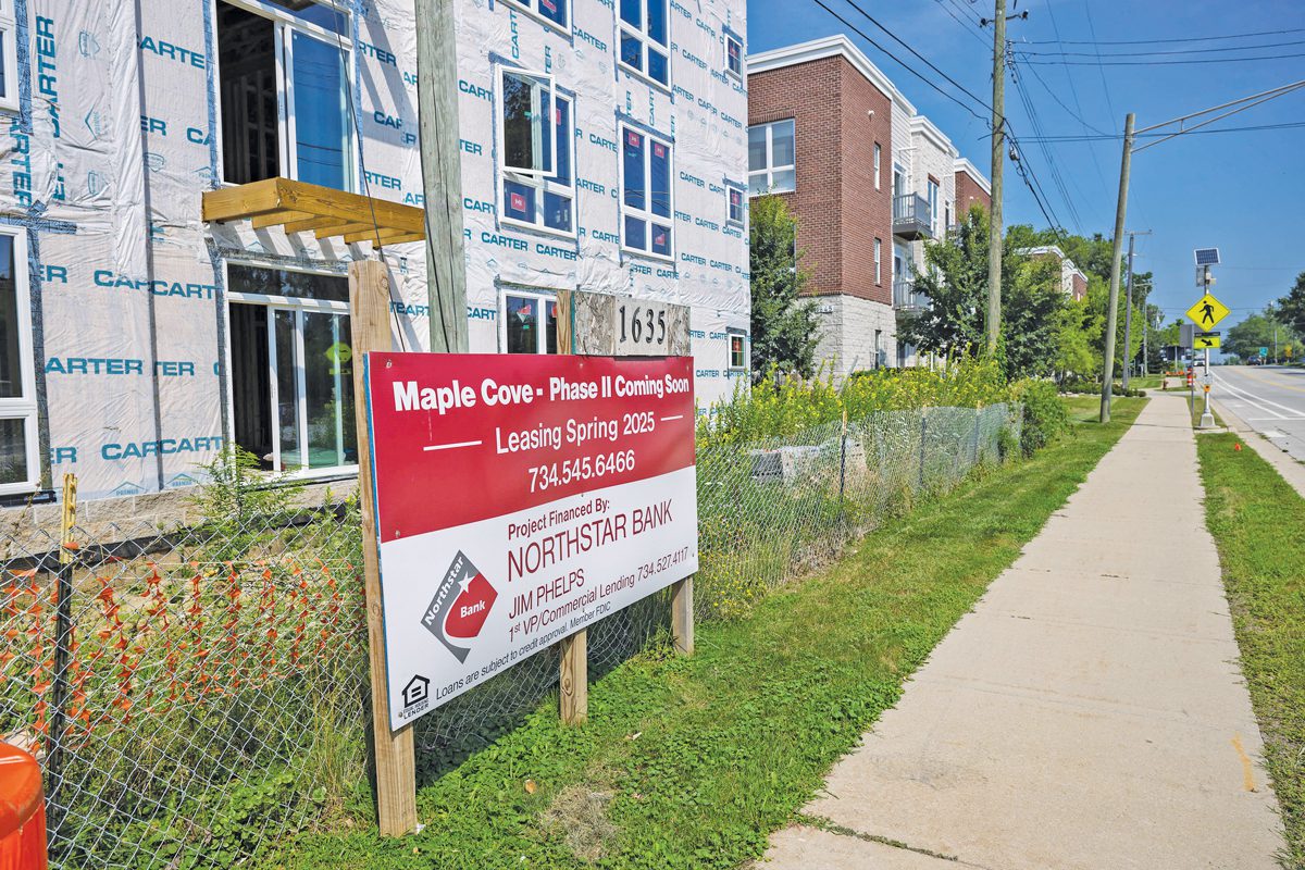 exterior of a sign advertising leases on apartments in the background