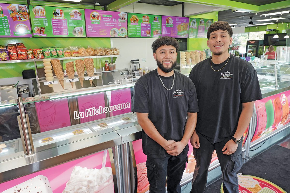 Two young men stand in a brightly colored ice cream shop