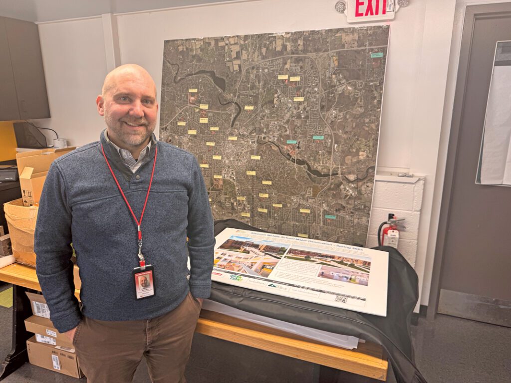 A man standing in front of a map.