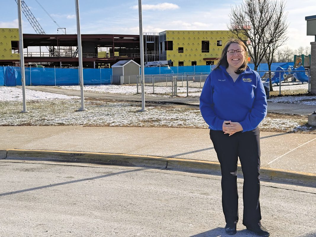 A woman standing in front of a building. 