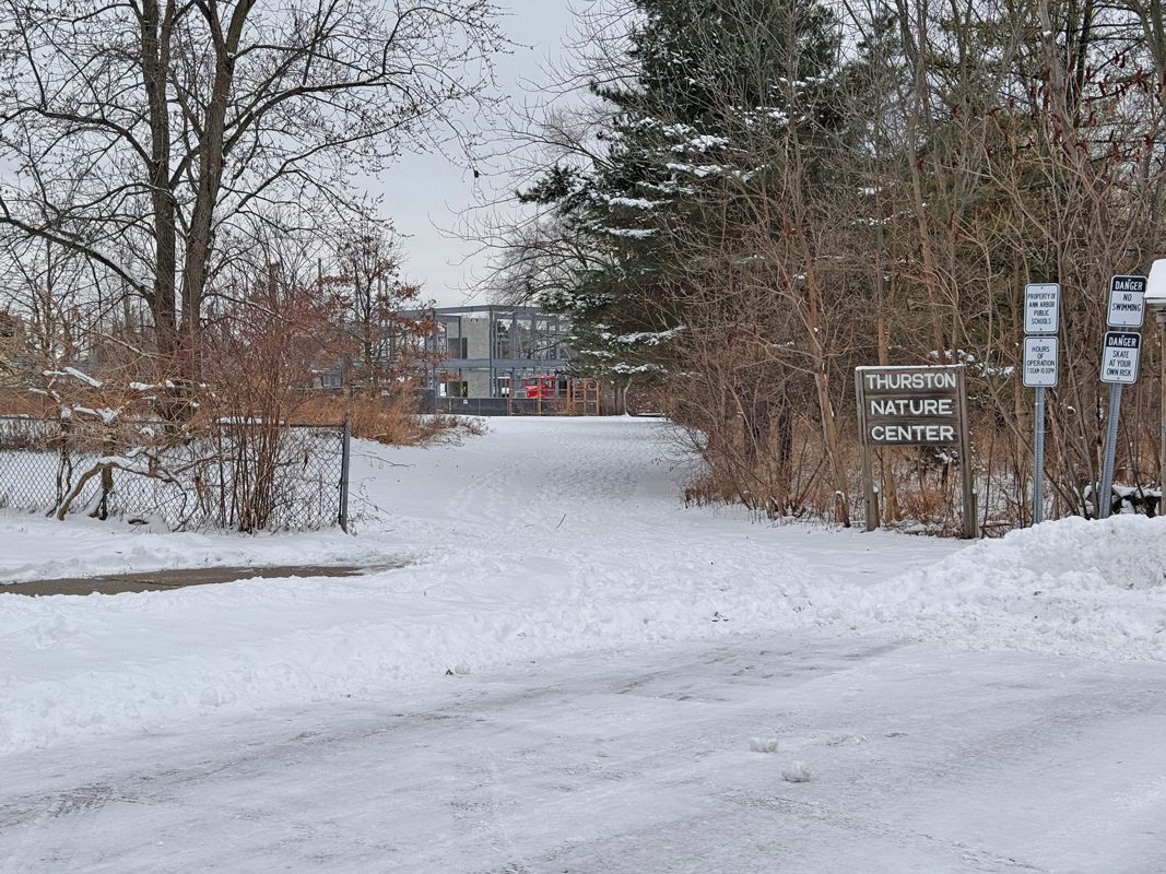 A snowy natural area with a school rising in the background