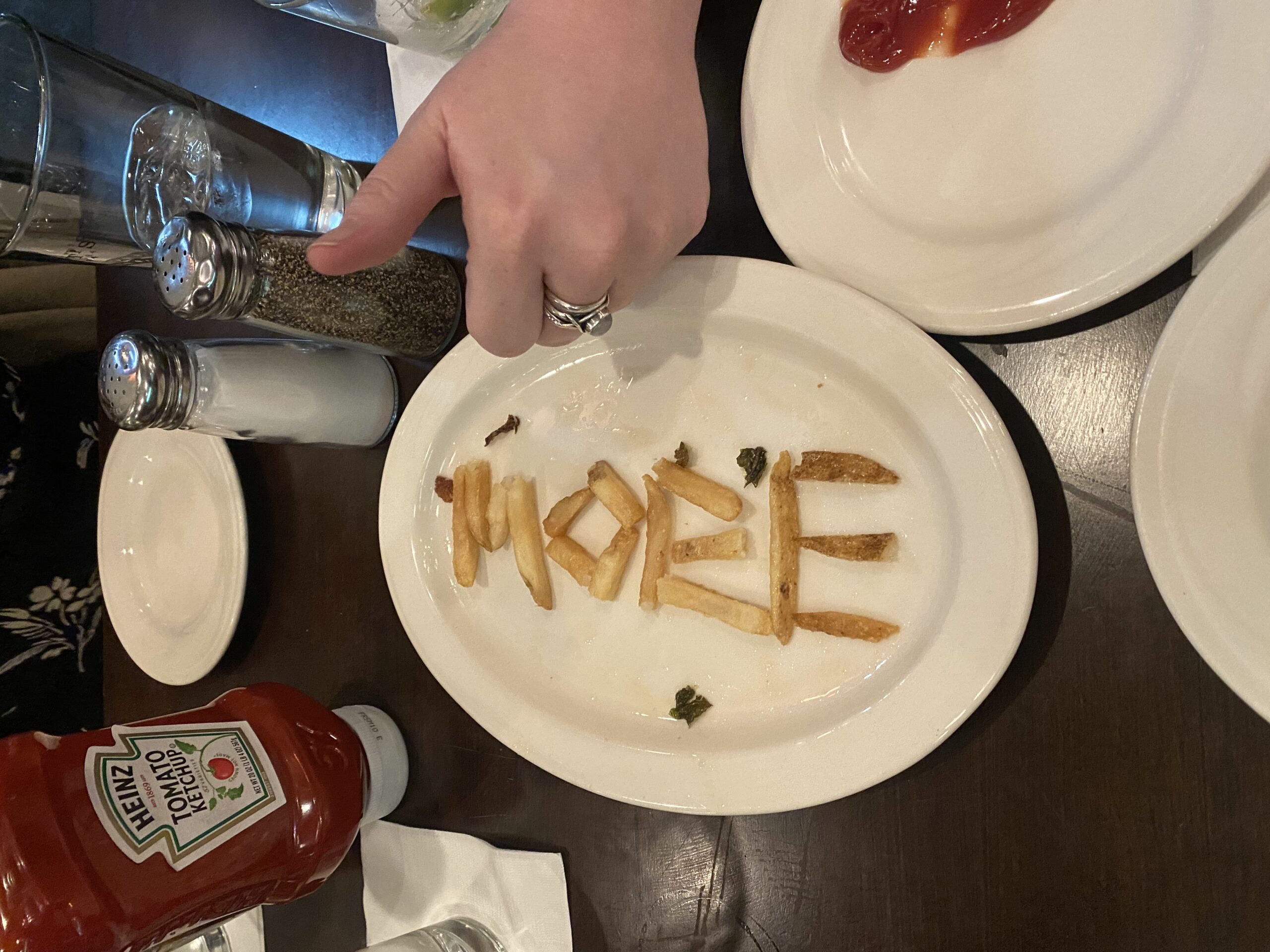A plate of french fries arranged to spell the word MORE. 