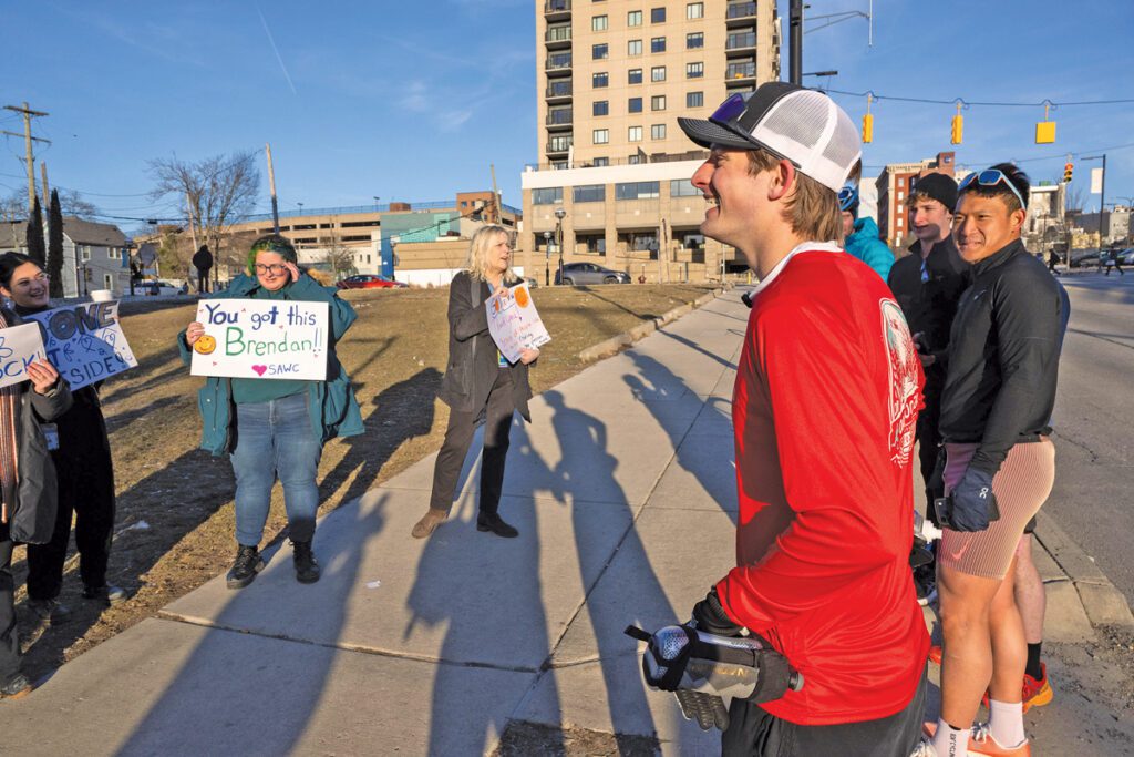 Brendan LaFrenier stands with his supporters, who are holding signs with encouraging messages.
