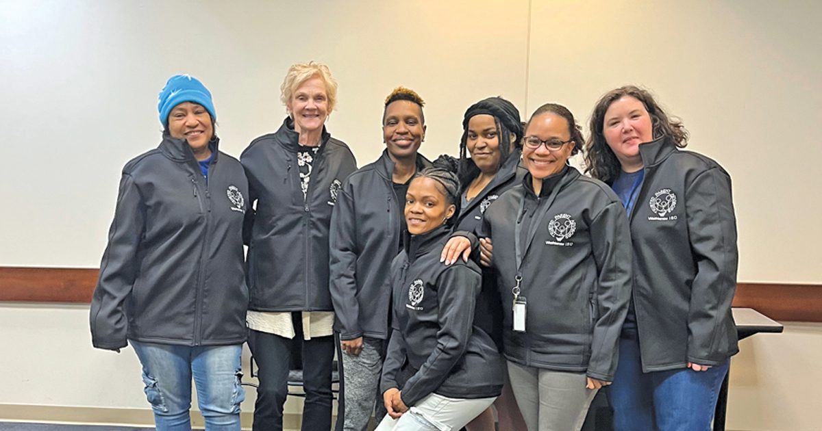 A group of seven people pose for a photo.