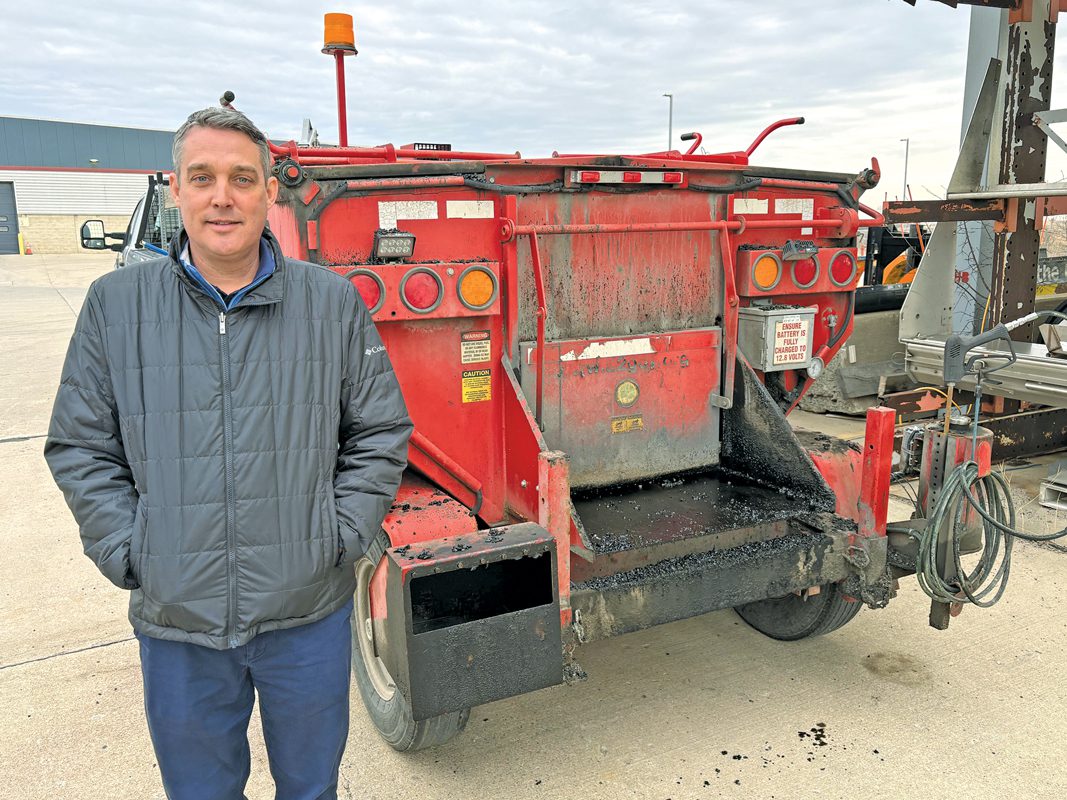 Paul Matthews standing in front of a piece of construction equipment.