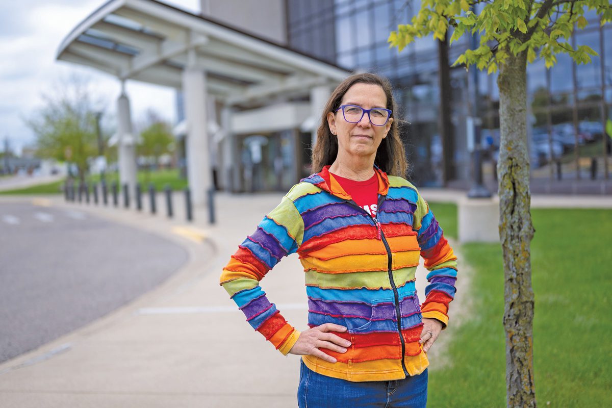 Cathy Marshall stands in a rainbow hoodie