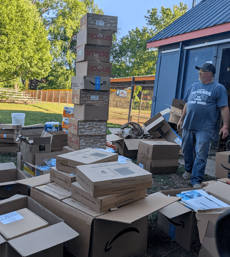 man lookijng at mounds of shipping boxes piled up