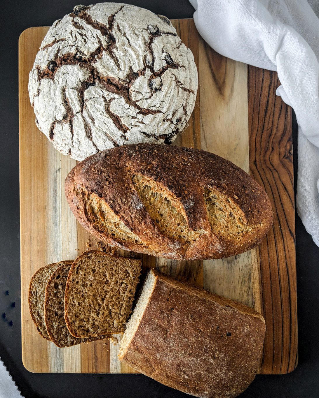 3 loaves of bread on a wooden cutting board