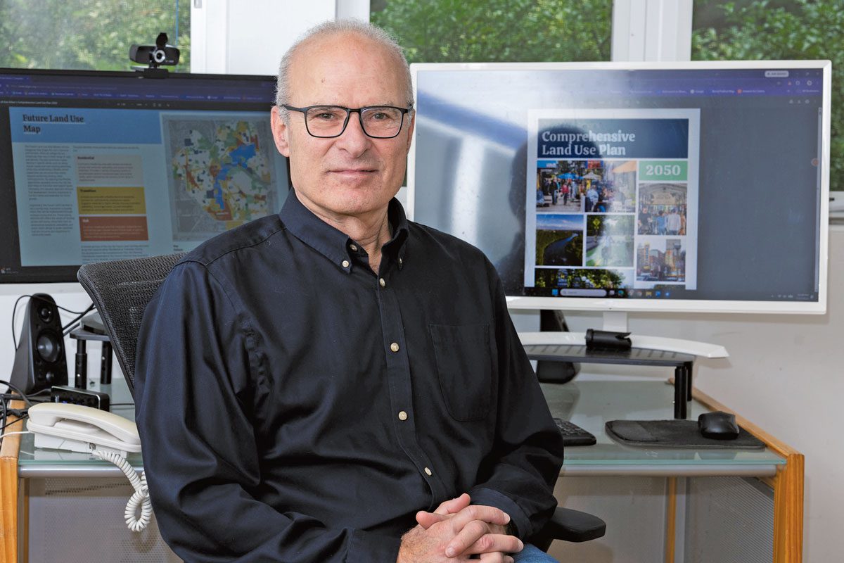 Jonathan Levine sits at a desk in front of two computer screens. One one is the Comprehensive Land Use Plan
