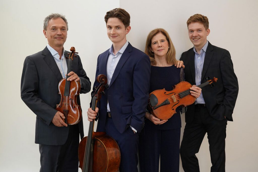 Aaron Berofsky holds a violin, Sebastian Berofsky holds a cello, Kathryn Votapek holds a viola, and Charles Berofsky.