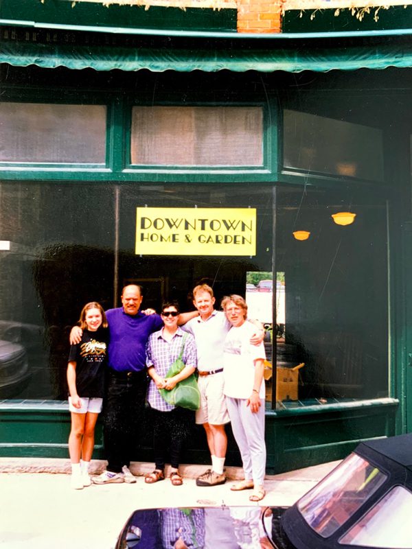 Old photo of four adults and one kid stand outside the entrance to Downtown Home & Garden