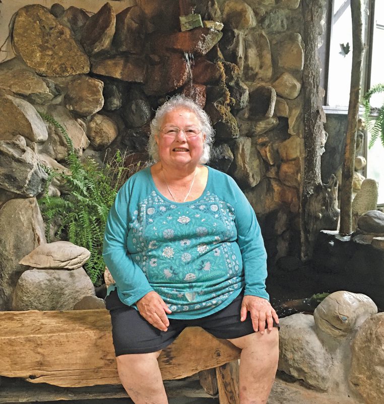 Portrait of Sue Golden in front of a stone wall. 