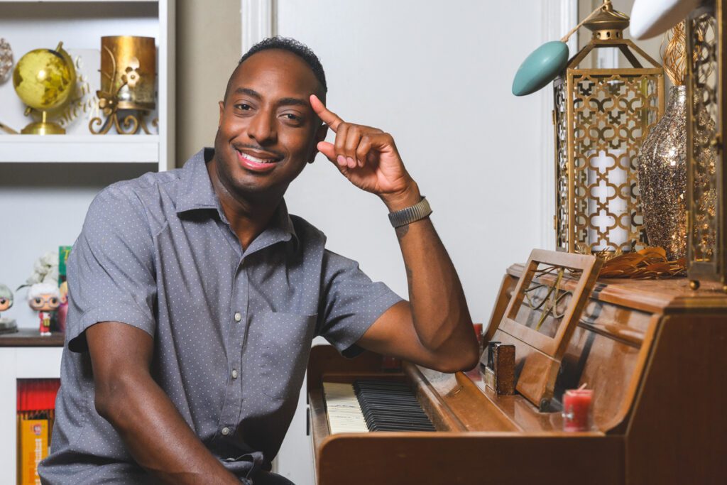 Chris Joseph sits at a piano in his home.